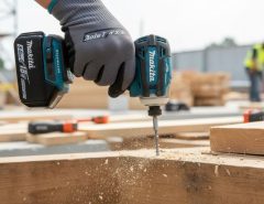 Makita XDT19Z cordless impact driver in action driving screws into wood on a job site