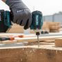 Makita XDT19Z cordless impact driver in action driving screws into wood on a job site