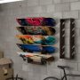 Multi-layer skateboard wall rack with hooks holding several decks vertically in a garage
