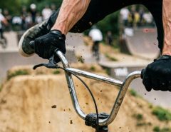 Close up of hands gripping durable bmx grips on handlebars.