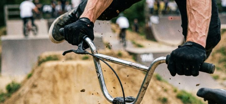 Close up of hands gripping durable bmx grips on handlebars.