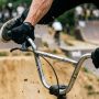 Close up of hands gripping durable bmx grips on handlebars.