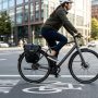 A mountain bike on a dirt trail next to a commuter bike on a city sidewalk.
