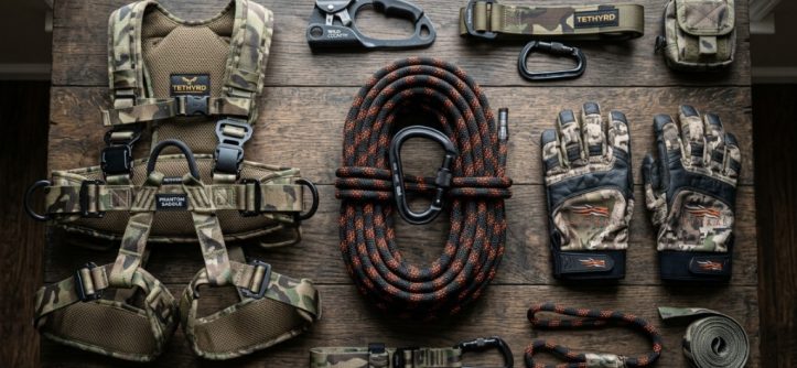 A coiled hunting rope with a carabiner neatly arranged next to safety gear.