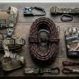 A coiled hunting rope with a carabiner neatly arranged next to safety gear.