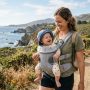 Parent wearing a lightweight baby carrier in a sunny California park.