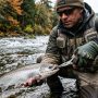 Angler wearing high-quality budget fishing gloves holding a fishing rod.