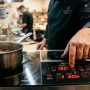 Modern 1800W induction cooktop boiling water in a sleek pot on a kitchen counter.