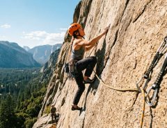Climber ascending a rock wall using a reliable dynamic climbing rope outdoors.