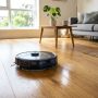 Sleek robot vacuum mopping a modern hardwood living room floor.
